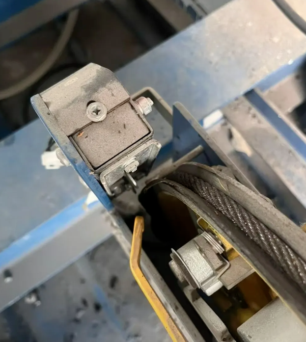 Está empezando a hacer frío y los cables del ascensor están cubiertos de aceite y mugre. El técnico de mantenimiento los está limpiando a toda velocidad; ¡tiene las manos destrozadas!